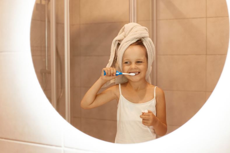 petite fille se brosser les dents dans la salle de bain